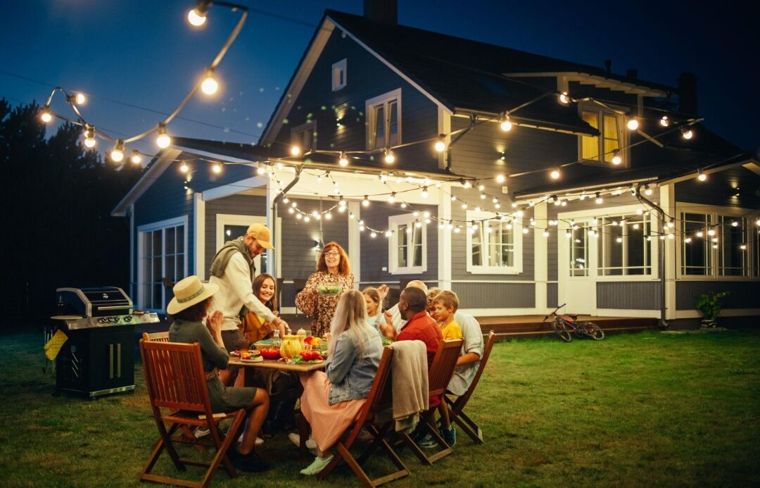 family sitting outside enjoying dinner on a summer night